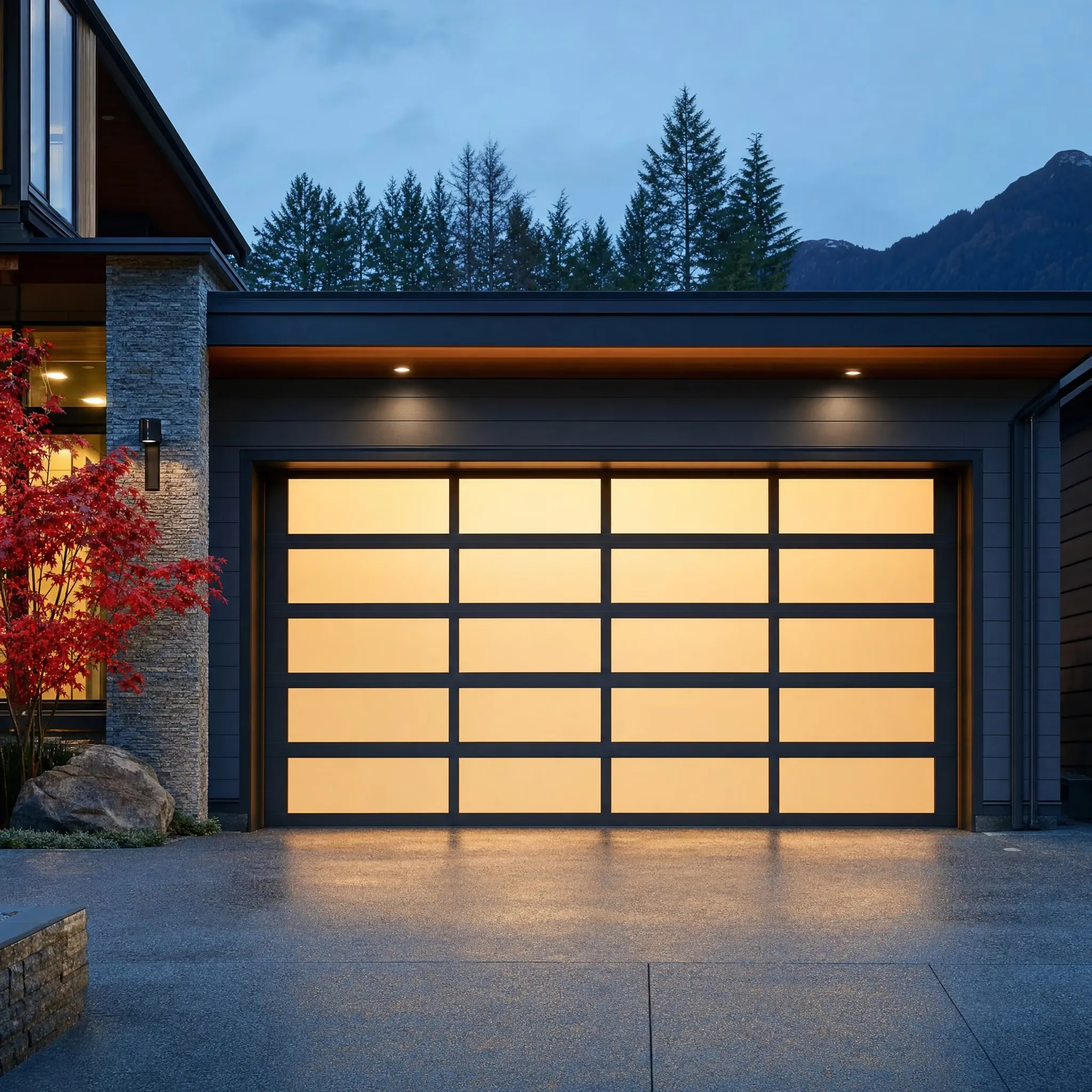 A full-view aluminum and frosted-glass garage door glowing at dusk on a modern BC home
